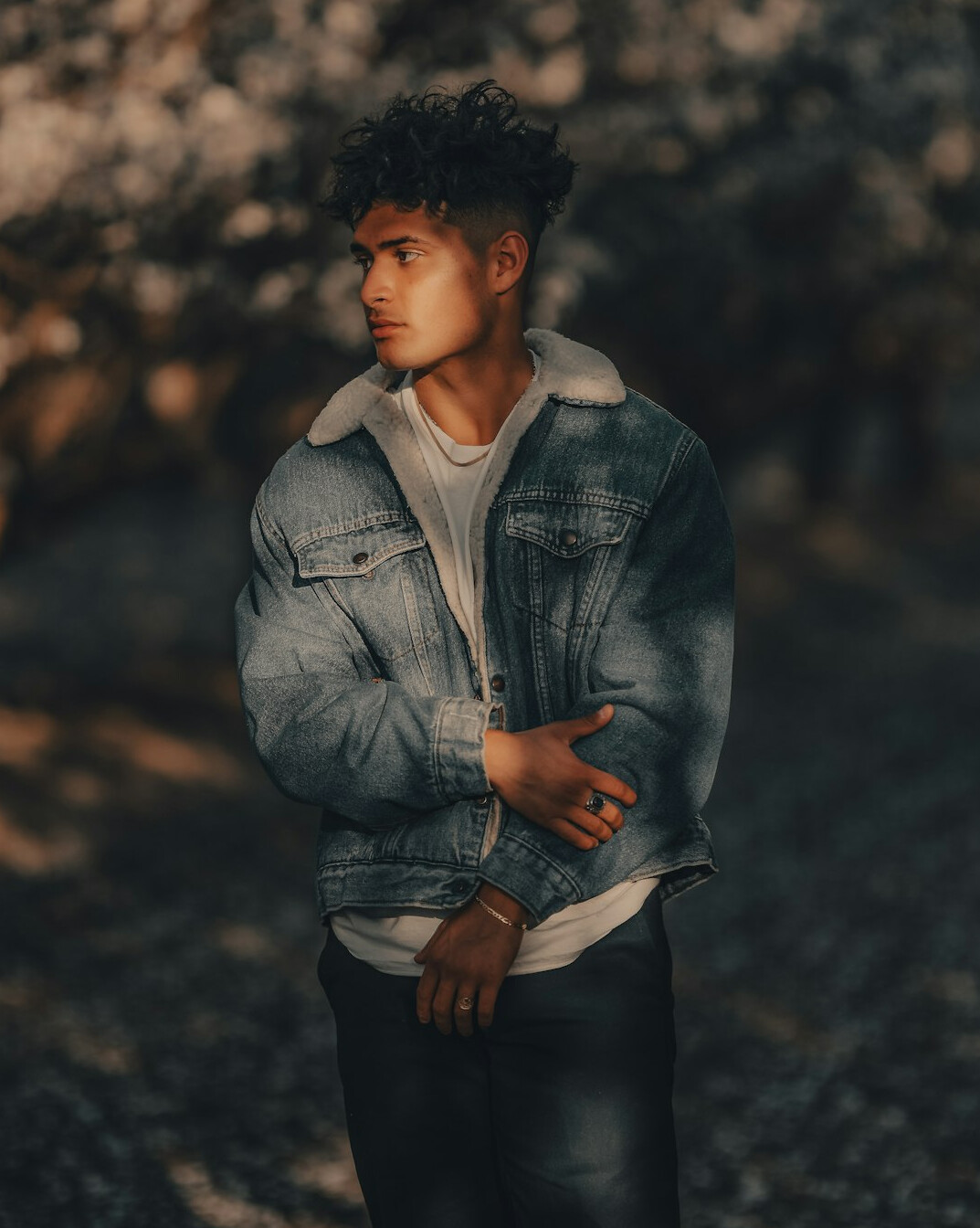 Portrait of a young man with curly hair in a denim jacket